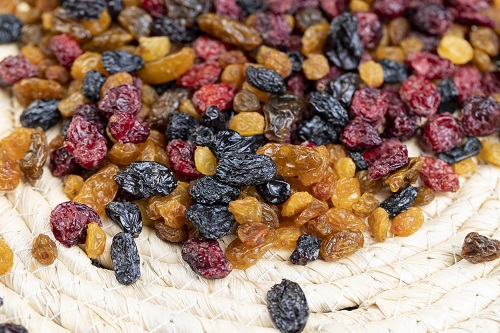 dried fruits of red cranberries and raisins mixed together, different types of dried berries on the kitchen table